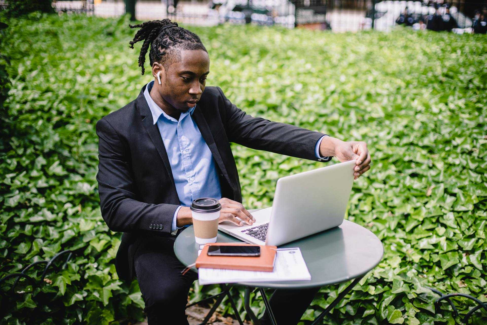 Black man using his computer outside